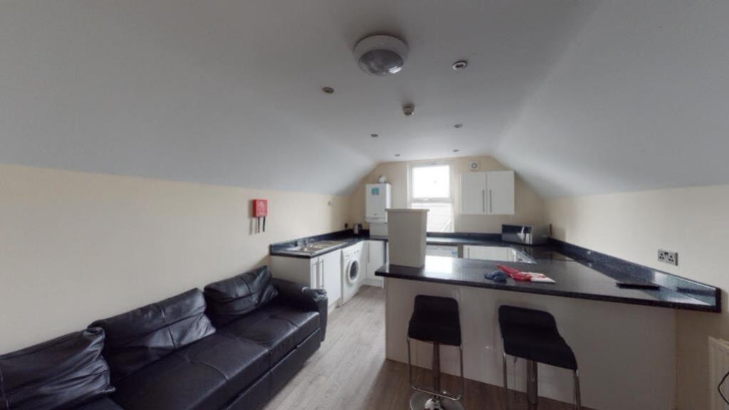 Modern kitchen area featuring a sleek black cou...