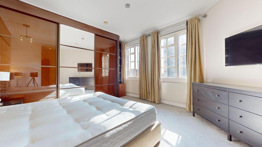 Bright and spacious master bedroom featuring la...