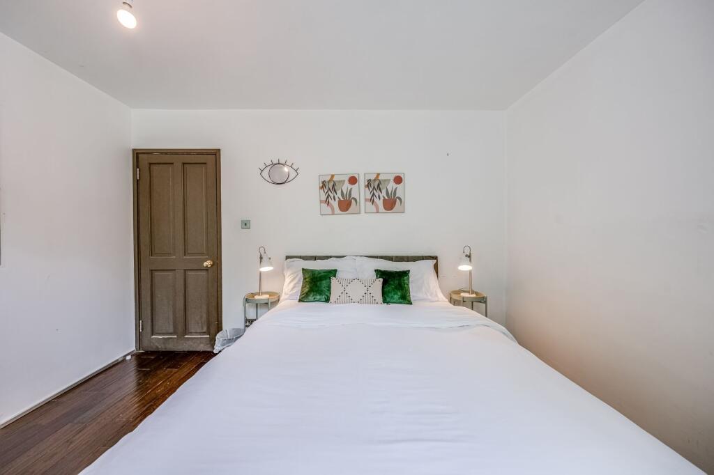 A cozy double bedroom featuring a neatly made b...