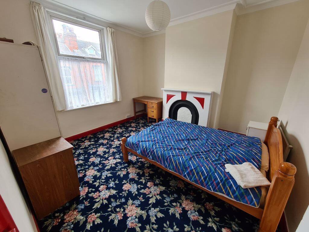 Cozy bedroom featuring a wooden framed bed with...