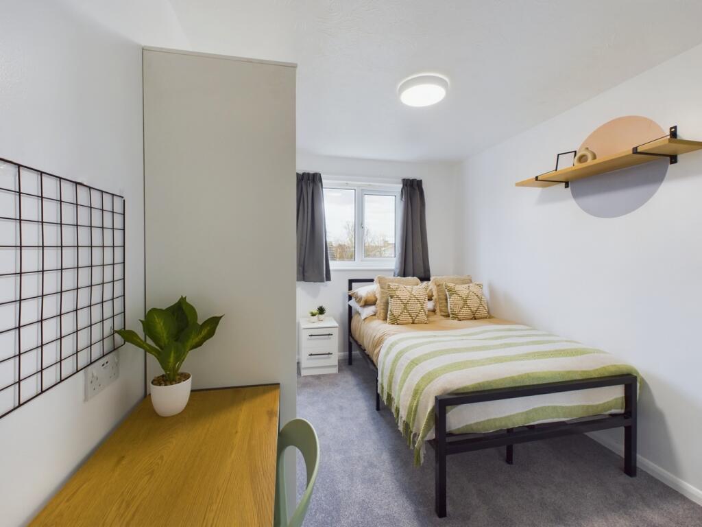 A bright and inviting double bedroom with a coz...