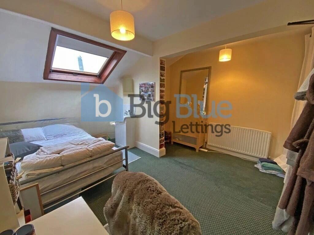 A bright double bedroom featuring a comfortable...