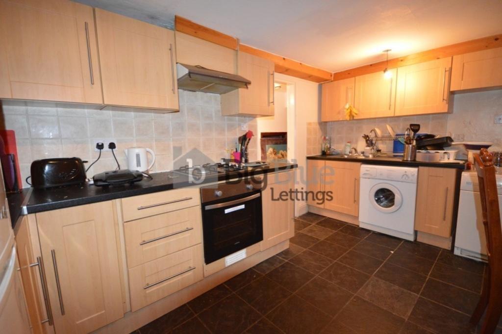 A well-equipped kitchen with modern wooden cabi...