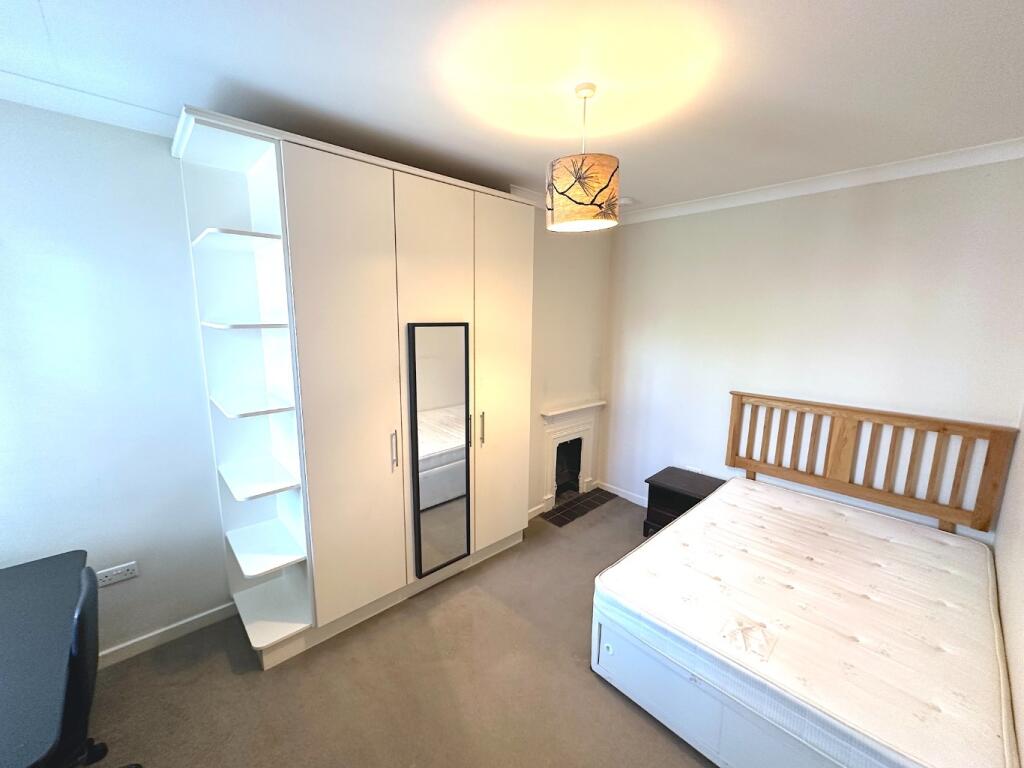 Bright furnished bedroom with a double bed, bui...