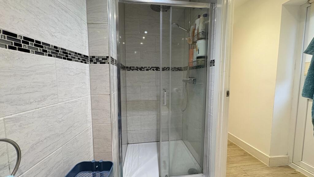 Modern bathroom with a glass-enclosed shower, t...