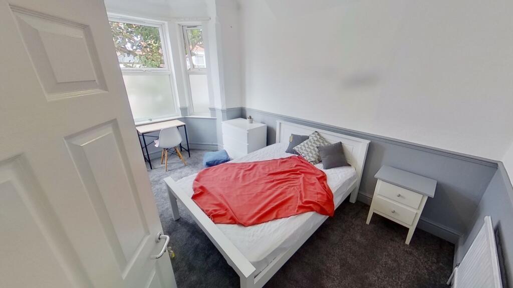 A clean and simple single toilet room with whit...