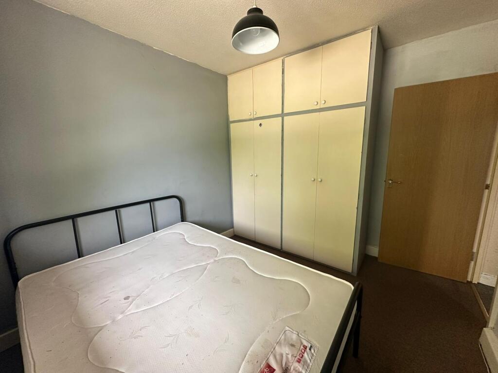 A cozy double bedroom featuring a sturdy metal ...