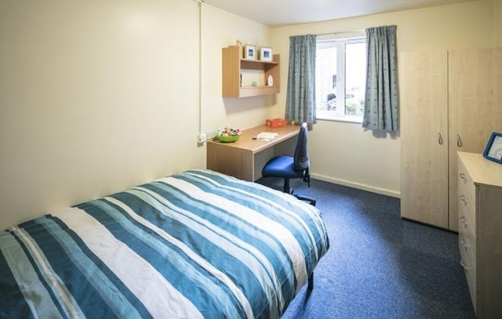 A bright and tidy double bedroom with ample des...