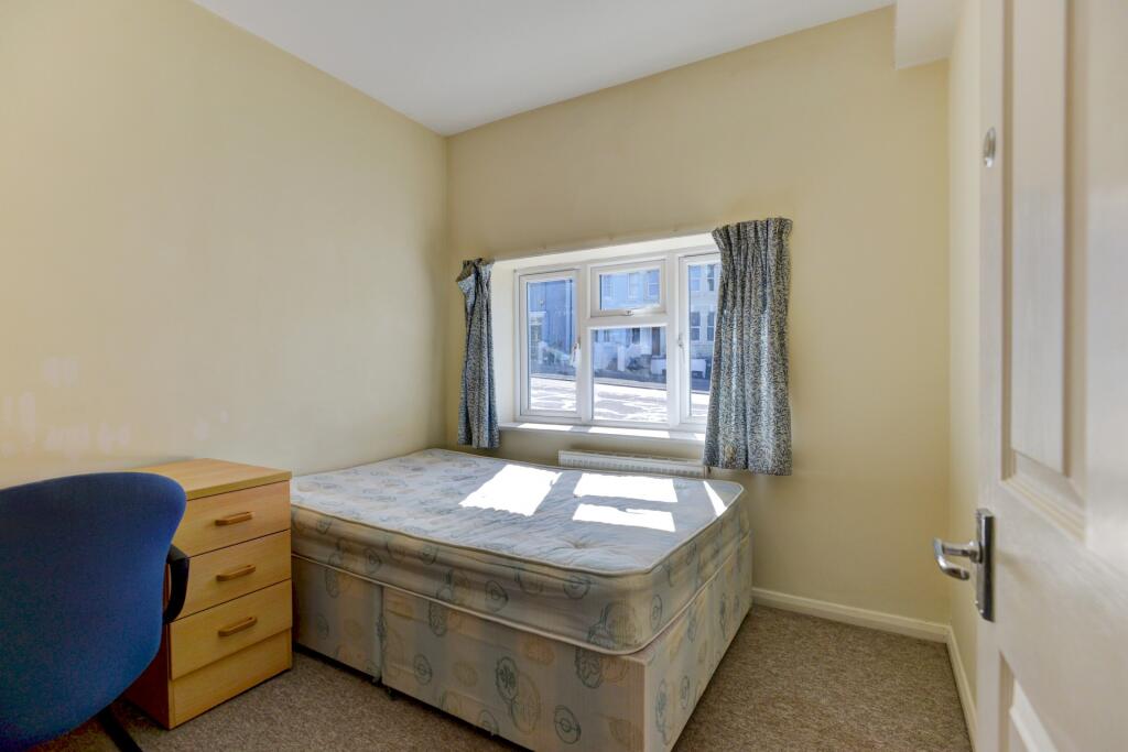 Bright single bedroom with a large window allow...