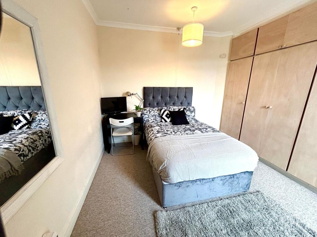 This cozy double bedroom features a comfortable...