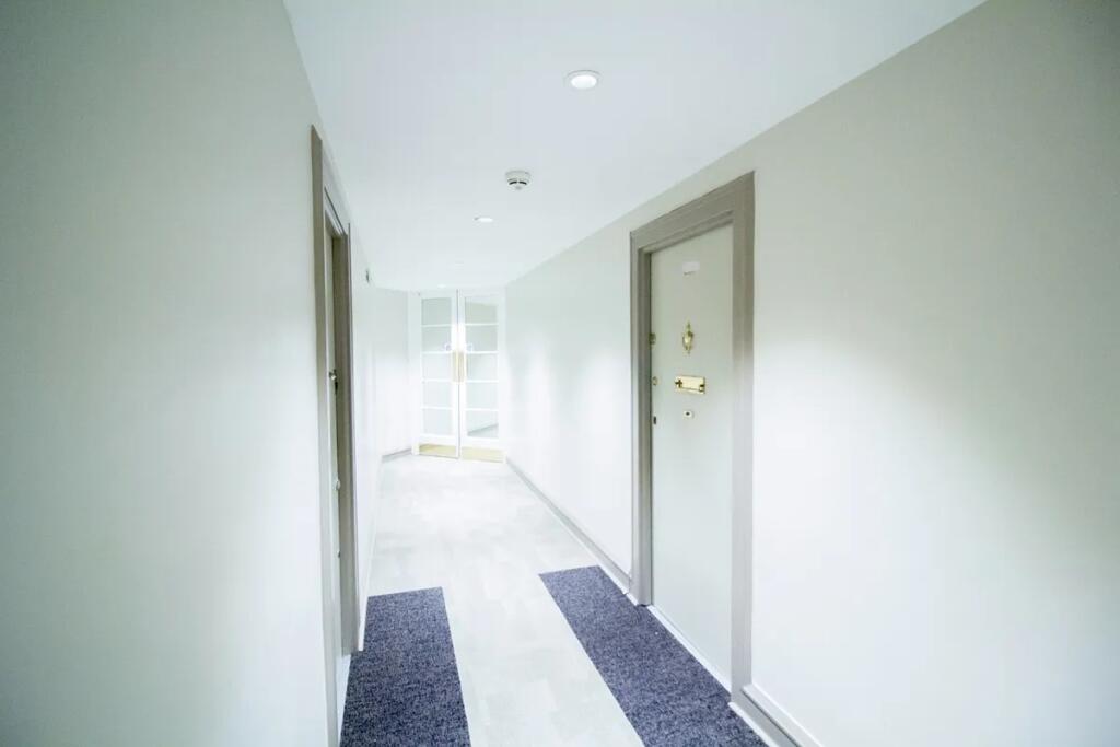 Bright and clean hallway with neutral tones and...