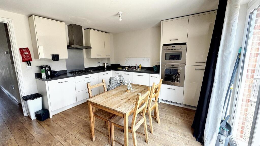 Bright and modern kitchen with white cabinetry ...