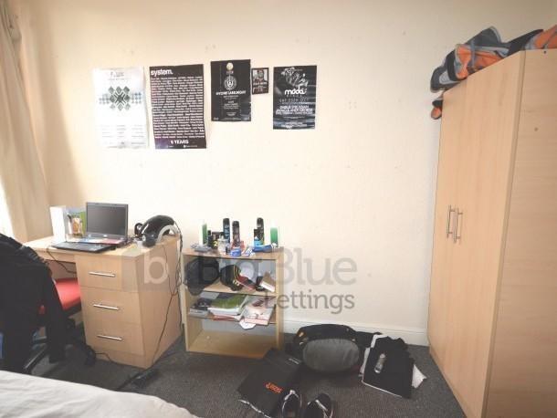 Cozy student bedroom featuring practical furnit...