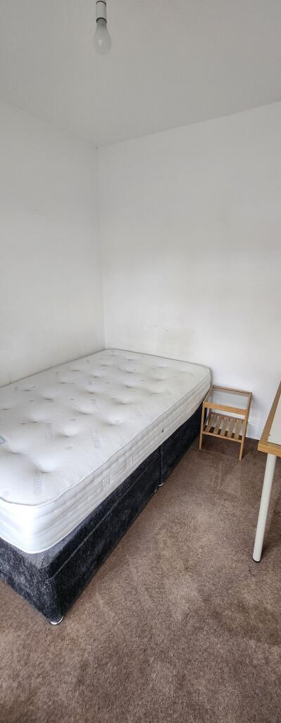 A simple, tidy single bedroom featuring a comfo...