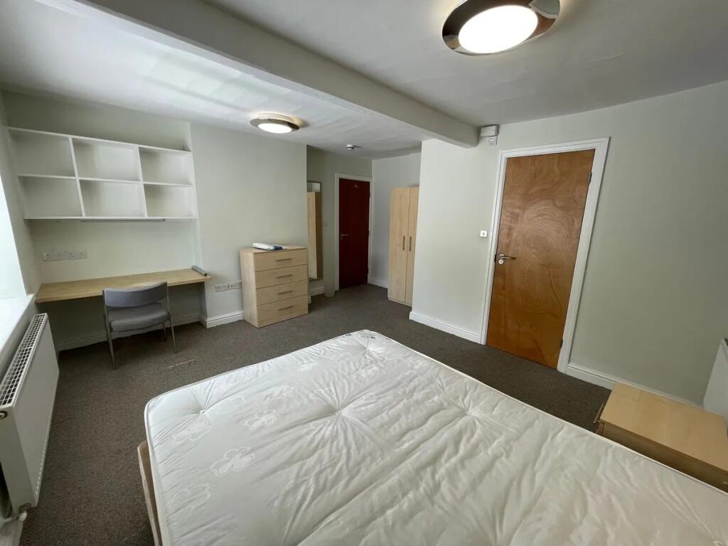 A bright double bedroom featuring a comfortable...