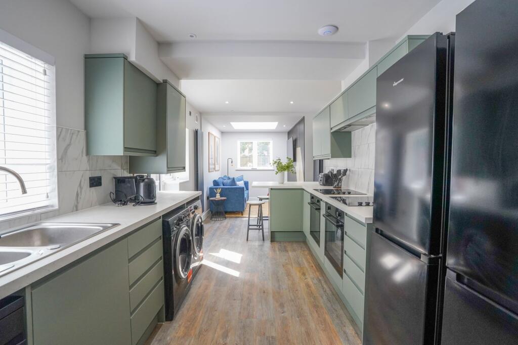 A modern kitchen featuring sleek cabinetry in a...