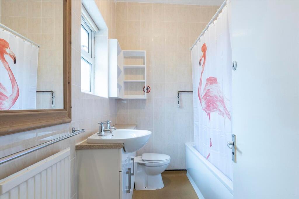 Bright and clean bathroom featuring a bathtub a...