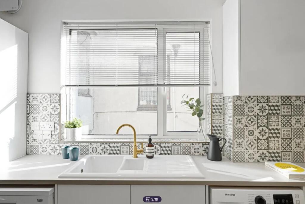 A bright and modern kitchenette with stylish de...