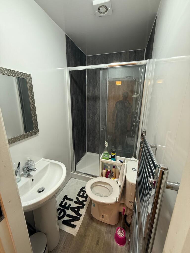 A compact, modern bathroom featuring a white pe...