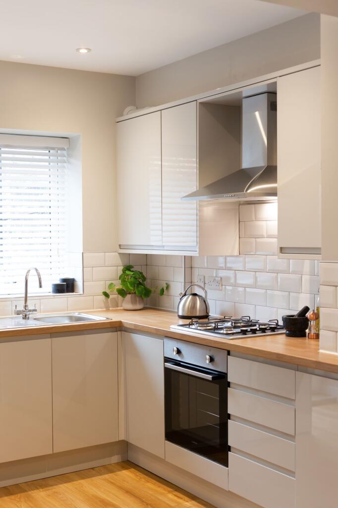 Modern and bright kitchen featuring white cabin...