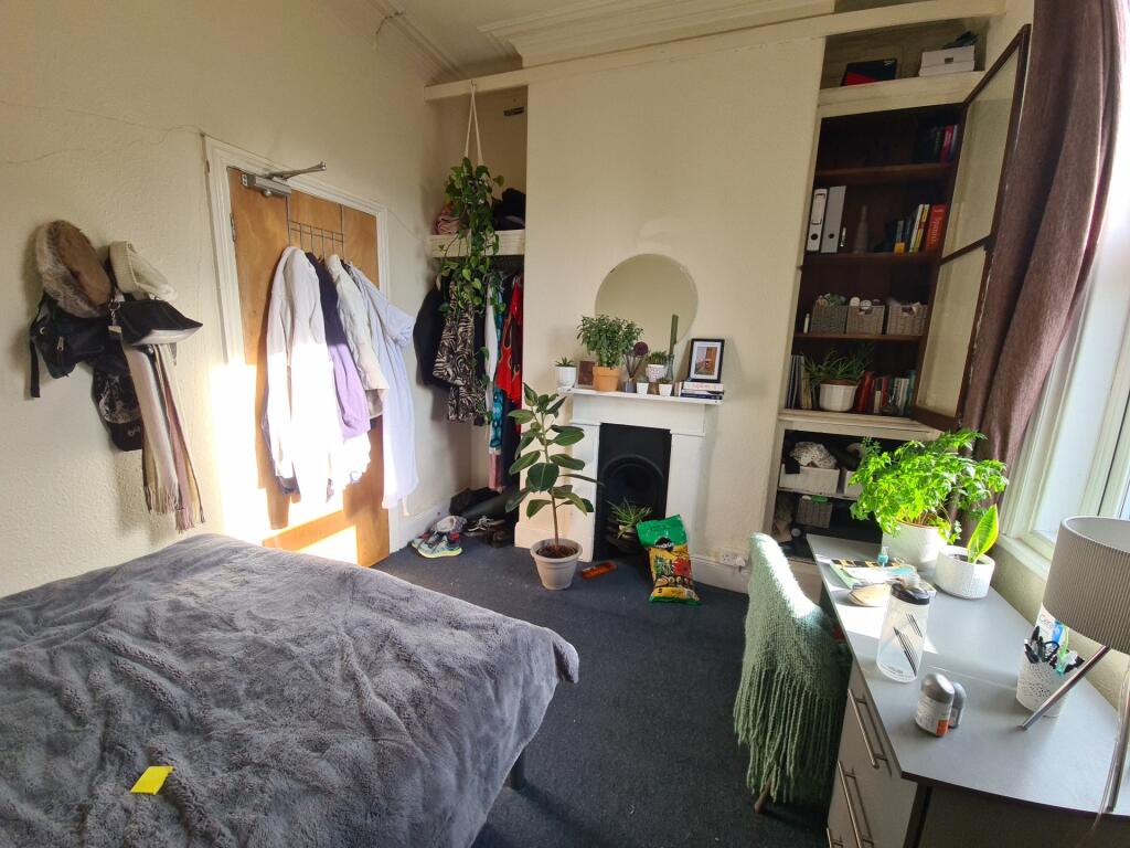 A well-lit bedroom featuring a large bed, ample...