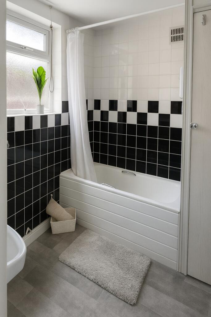 Bright, modern bathroom with a tiled bathtub an...