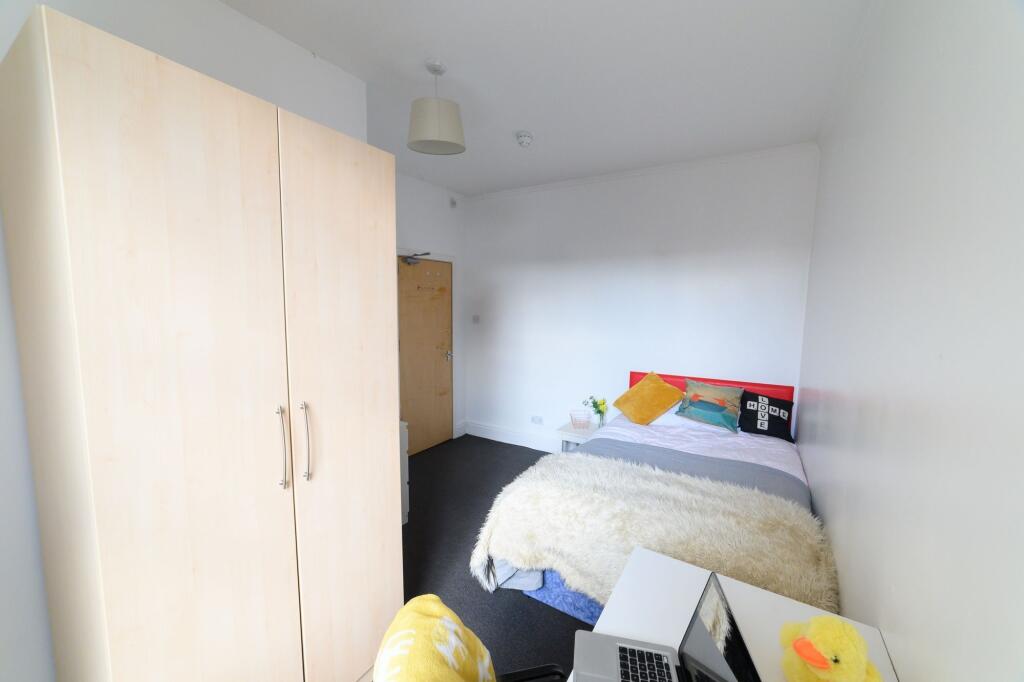 A cozy bedroom featuring a double bed with colo...