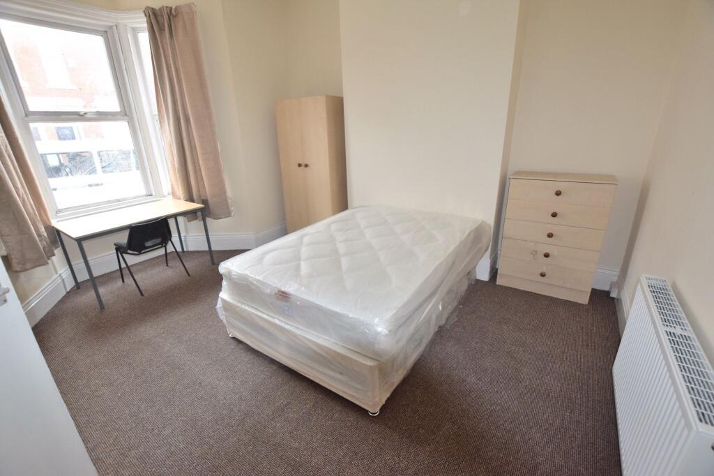 Bright, neutral double bedroom with a large bay...