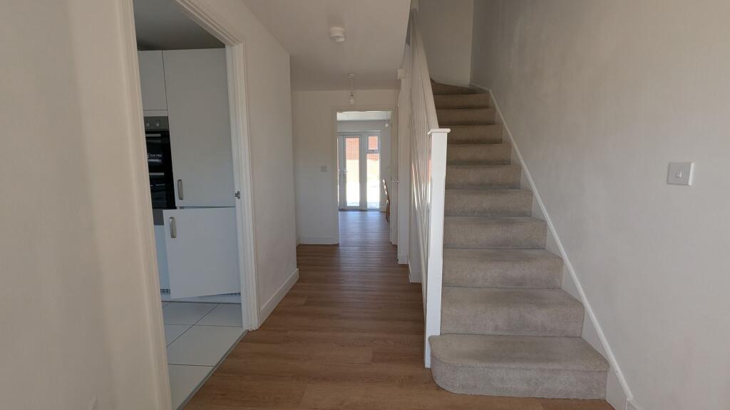 Bright, modern entrance hallway with wood-effec...