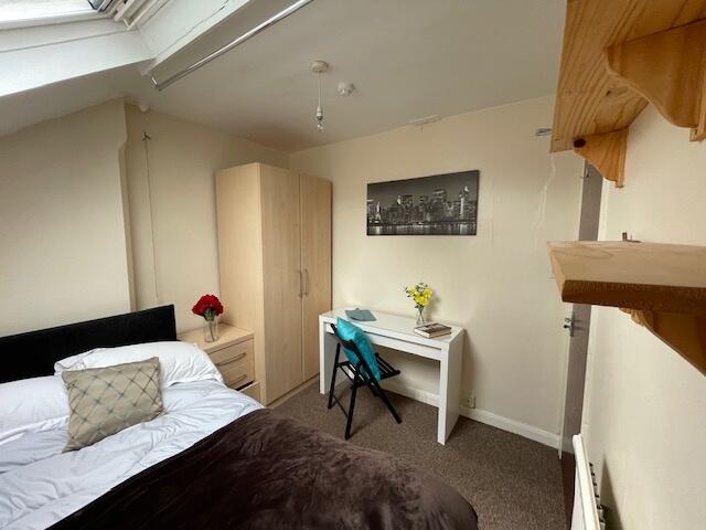 A cozy and tidy bedroom featuring a comfortable...
