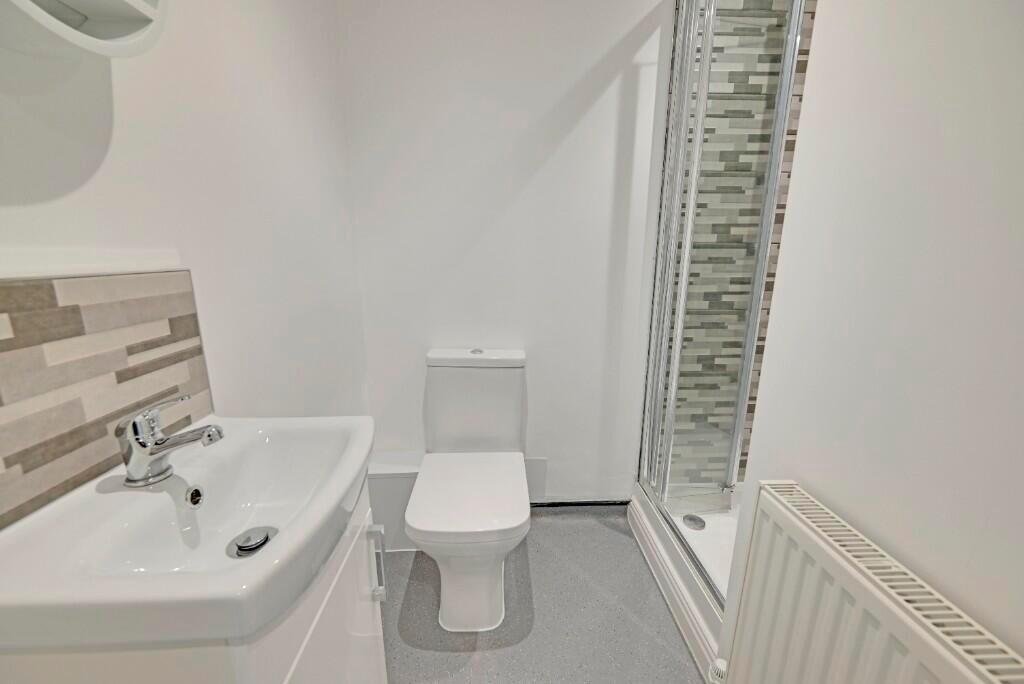 Bright and modern bathroom suite featuring a sl...