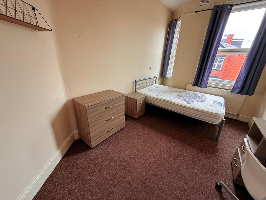 Bright furnished bedroom with a single bed by a...