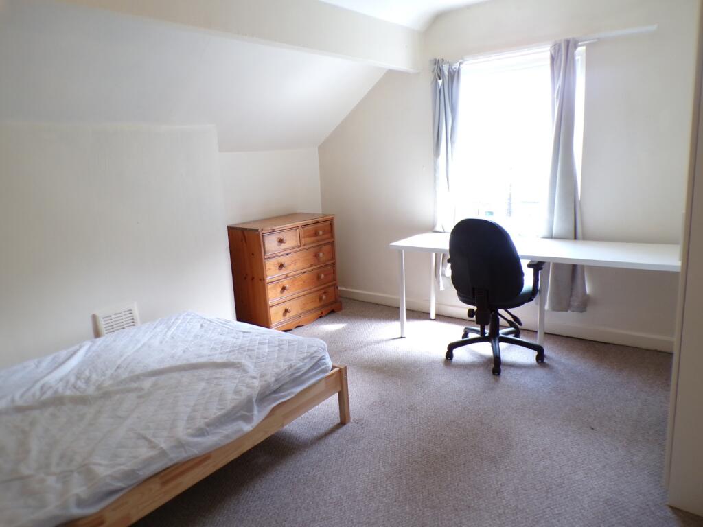 A spacious and bright double bedroom featuring ...