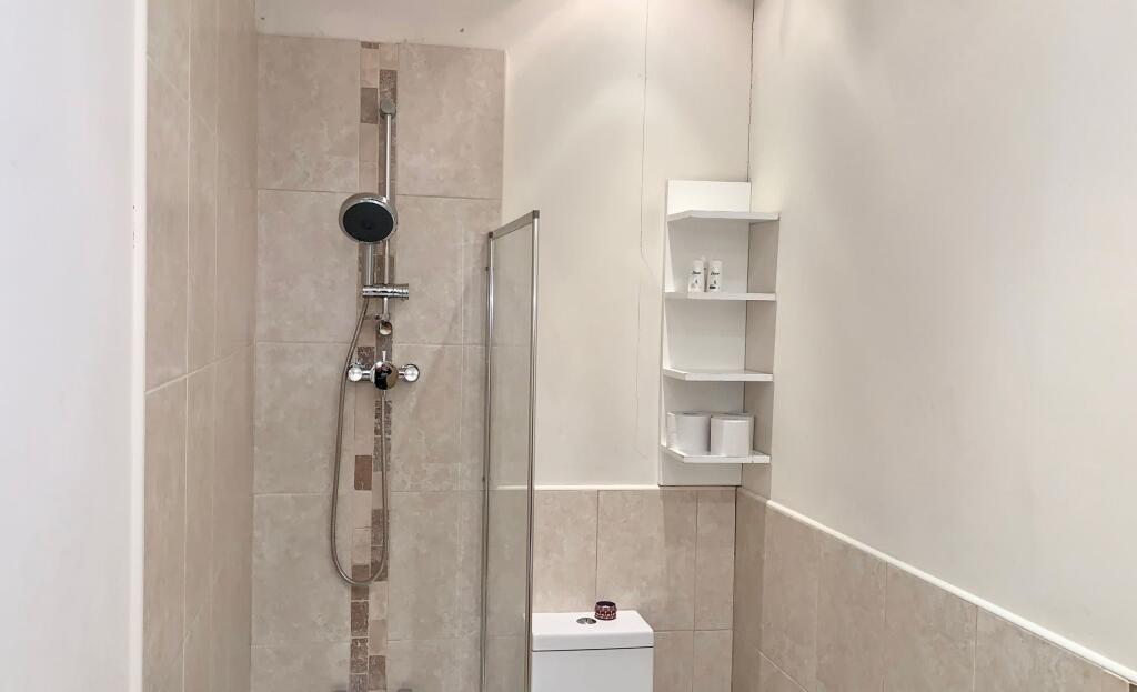 A modern bathroom featuring a walk-in shower wi...