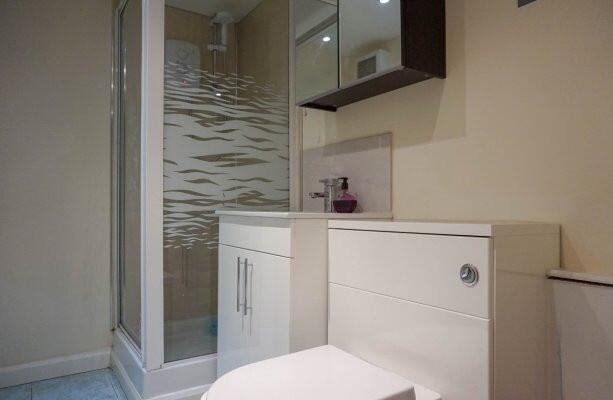 Modern bathroom with glass shower enclosure and...