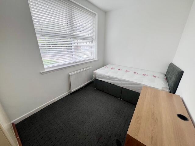 A neat and simple single bedroom featuring a la...