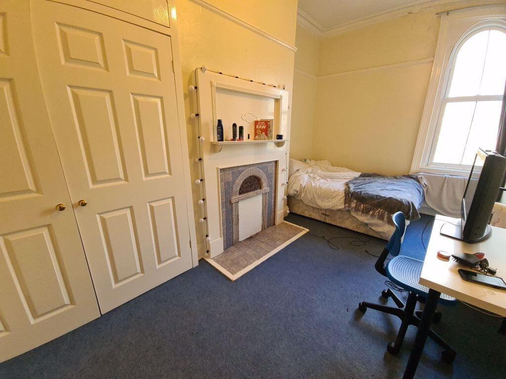 A cozy bedroom featuring a single bed, a window...