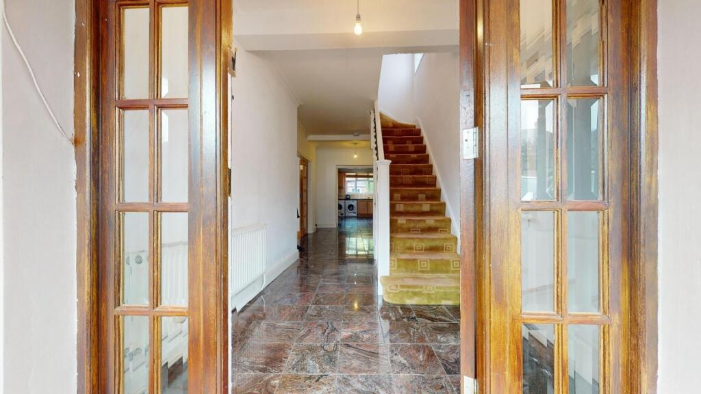 Bright hallway featuring glossy tiled floors an...