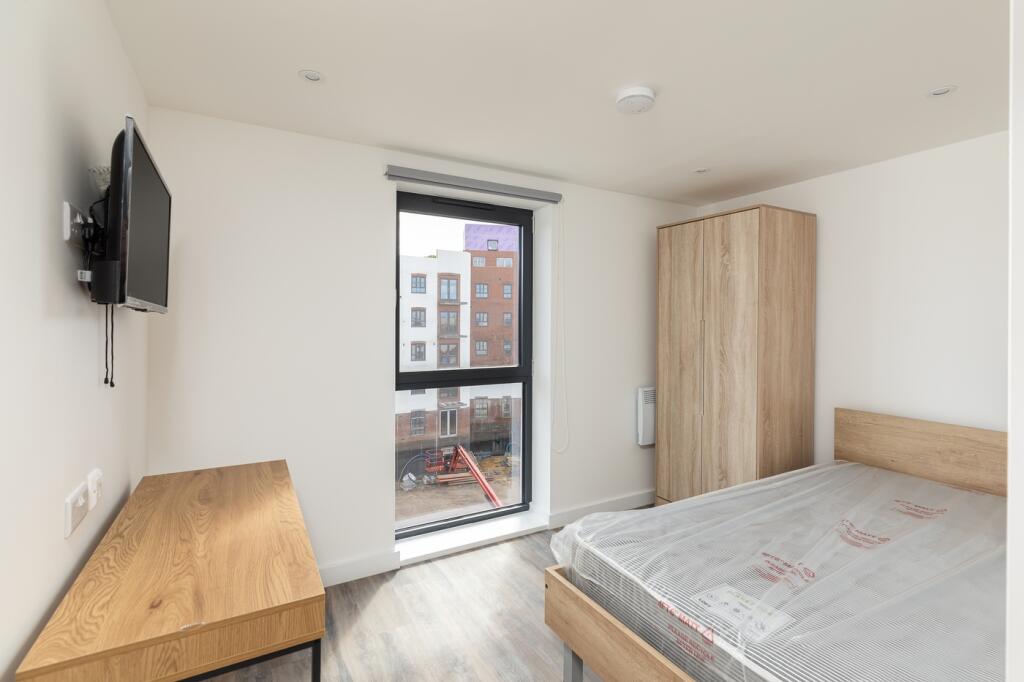 A bright and modern double bedroom featuring la...