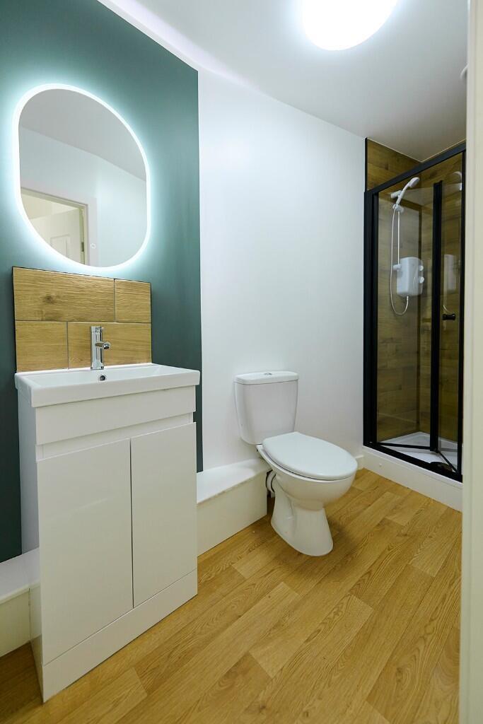 A modern bathroom featuring a sleek illuminated...