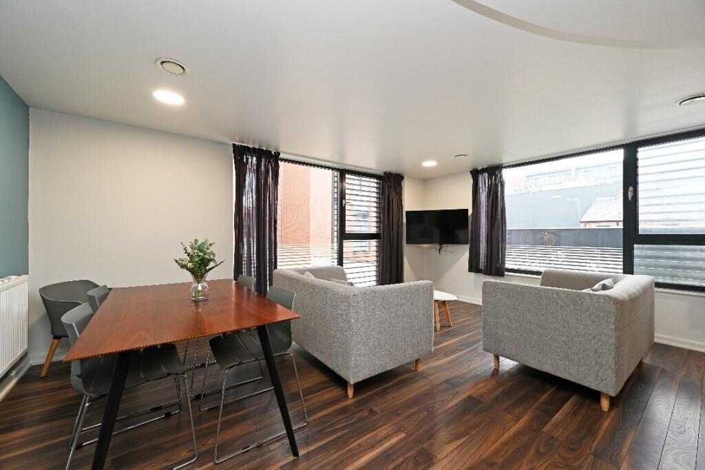 Bright and contemporary living room featuring a...