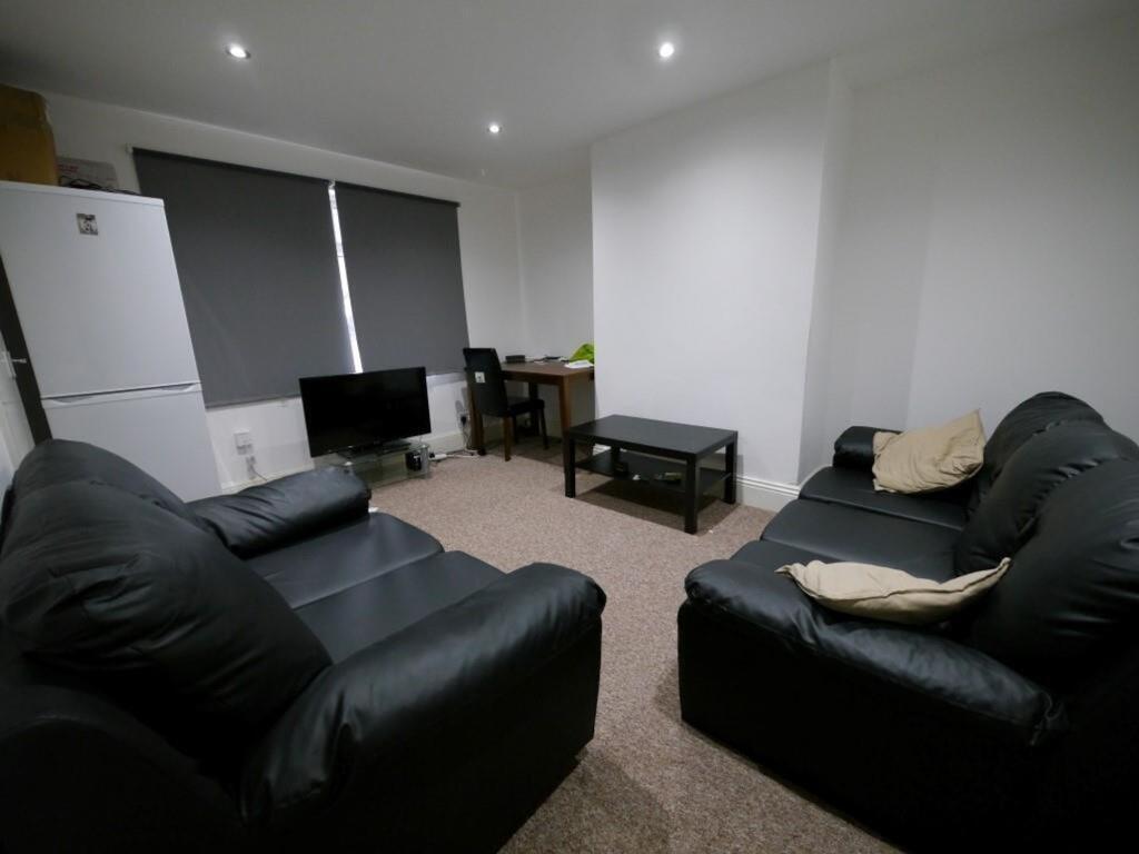 Cozy living room featuring two black leather so...