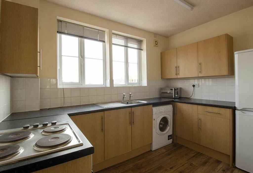 Spacious kitchen area featuring modern cabinetr...