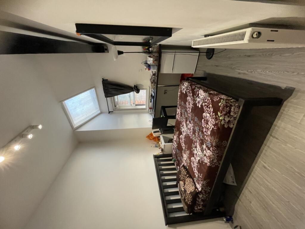 A neat and well-lit double bedroom featuring a ...