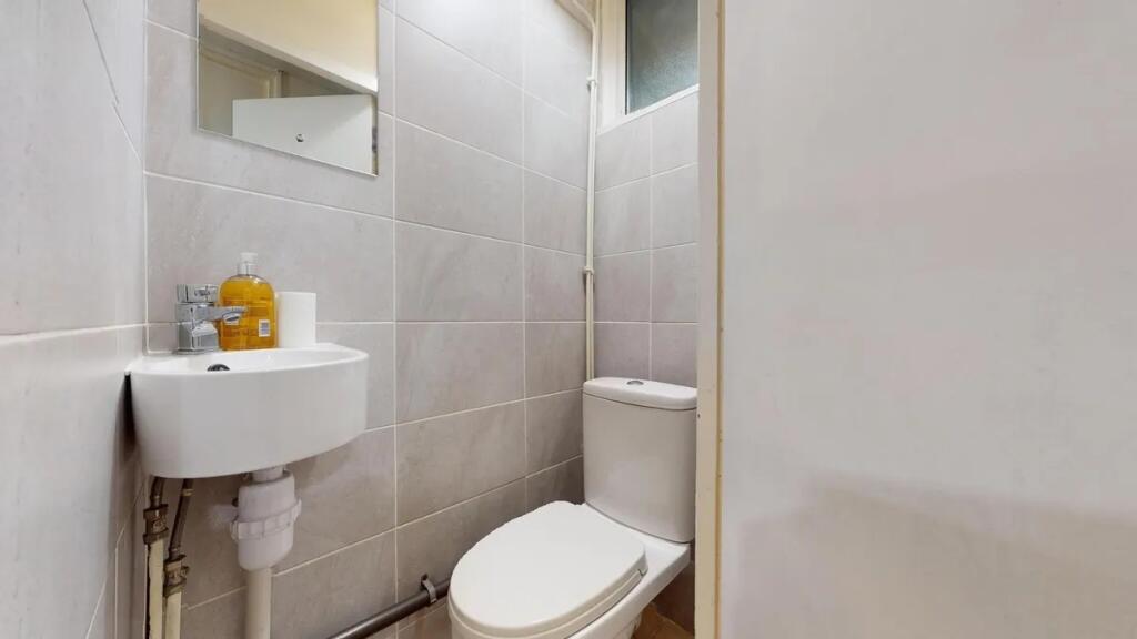 A compact, well-maintained single toilet featur...