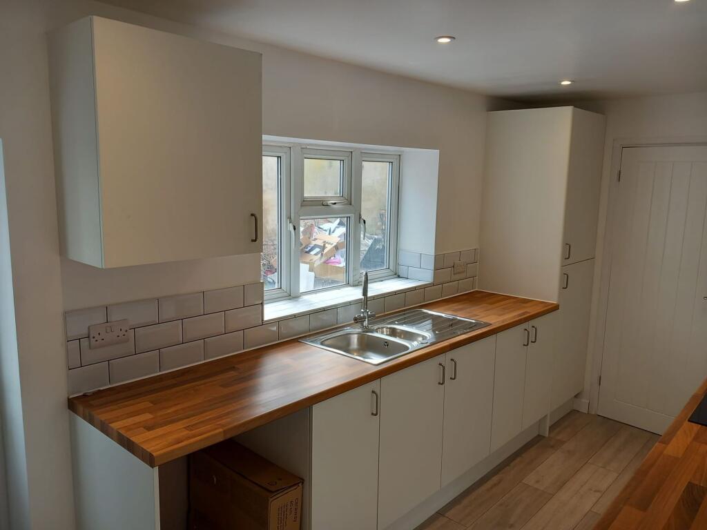 Bright and modern kitchen featuring clean woode...