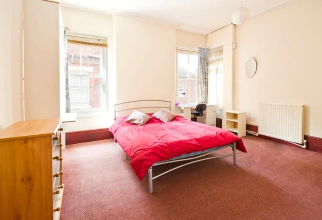 A spacious and bright double bedroom featuring ...