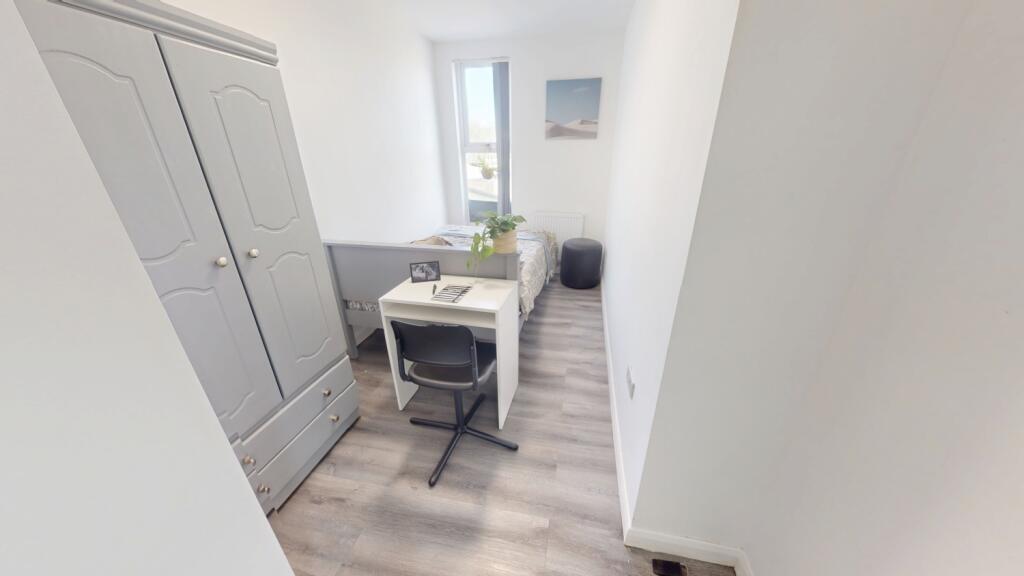 A bright and tidy single bedroom featuring a li...