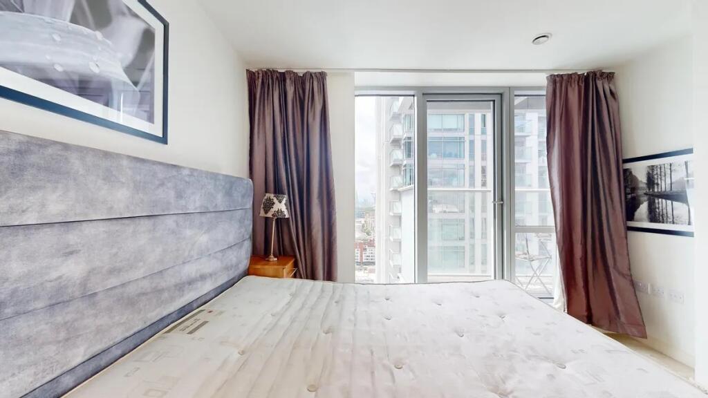 Bright and modern master bedroom featuring a la...