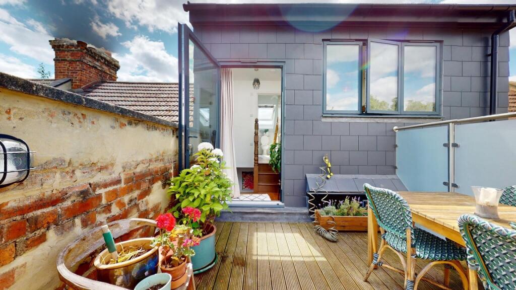 A charming outdoor garden terrace with wooden d...